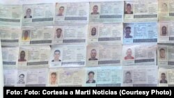 Imágenes de pasaportes cubanos reclutados por Rusia en una pancarta que llevaron activistas que se manifestaron en Washington contra la guerra een Ucrania